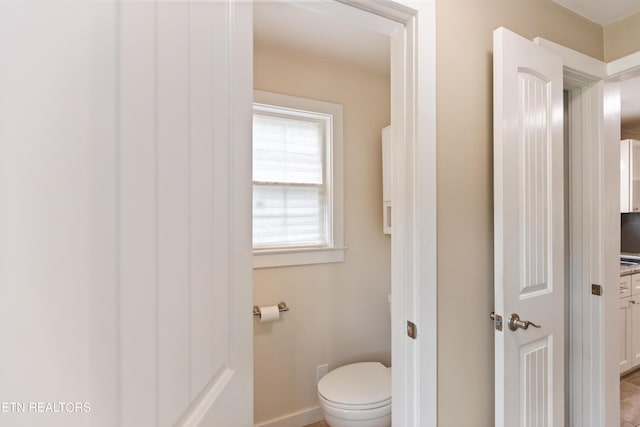 bathroom with toilet and baseboards