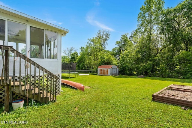 view of yard featuring an outbuilding, a trampoline, a sunroom, stairway, and a storage shed