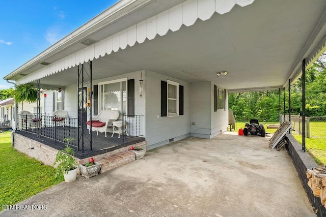 view of patio featuring covered porch, fence, and a carport