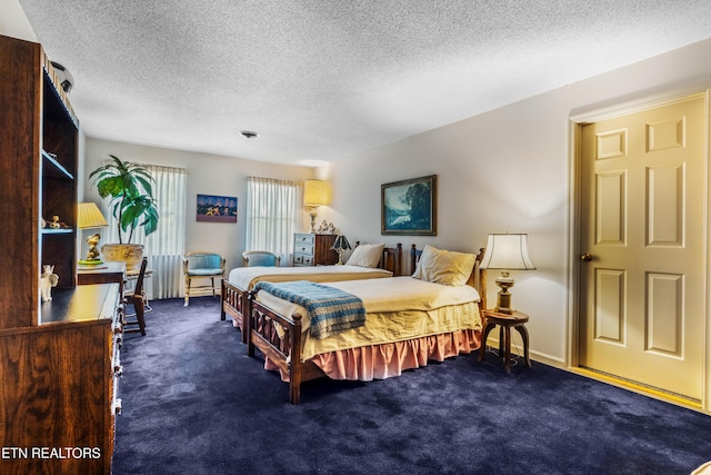 bedroom with dark colored carpet and a textured ceiling