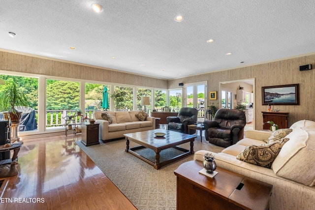 living area with wallpapered walls, plenty of natural light, and a textured ceiling