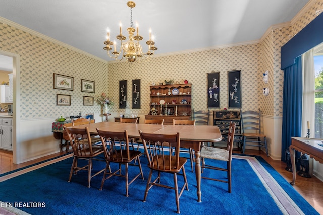 dining area with wood finished floors, wainscoting, and ornamental molding