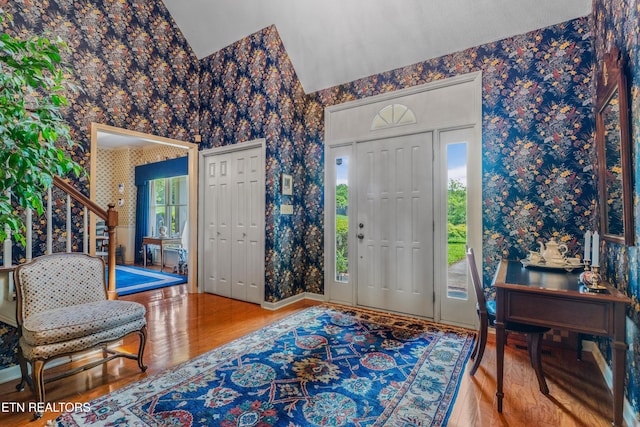 entrance foyer featuring wallpapered walls and wood finished floors