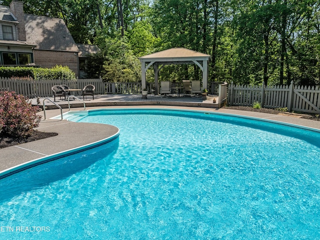 pool with a gazebo, fence, and a patio