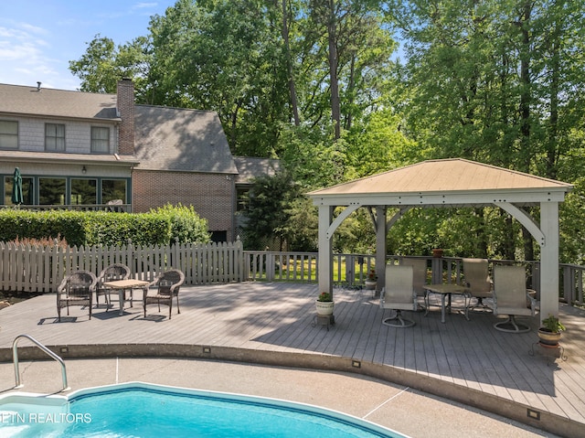 view of pool with a gazebo, a wooden deck, a fenced in pool, and fence