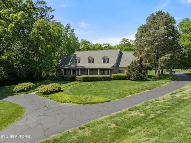 new england style home featuring a front yard