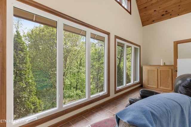 bedroom with multiple windows, tile patterned floors, and high vaulted ceiling