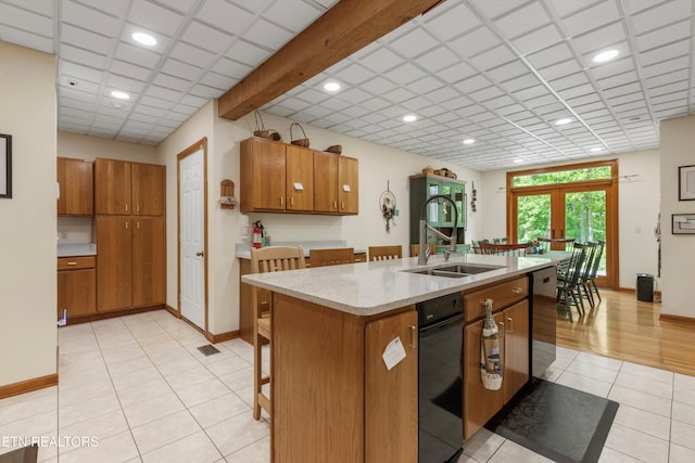 kitchen featuring a sink, brown cabinets, dishwasher, recessed lighting, and light tile patterned floors