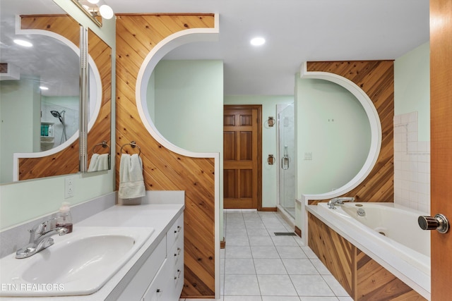 bathroom with a stall shower, wooden walls, tile patterned flooring, a bath, and vanity