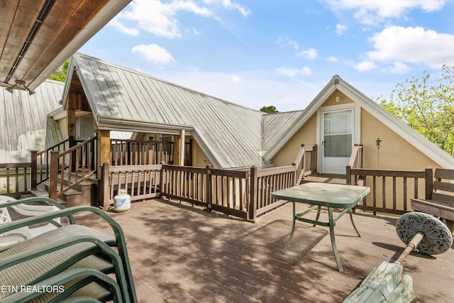 back of property featuring a wooden deck and metal roof