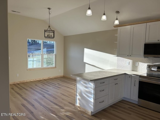 kitchen featuring decorative light fixtures, a peninsula, electric stove, vaulted ceiling, and wood finished floors