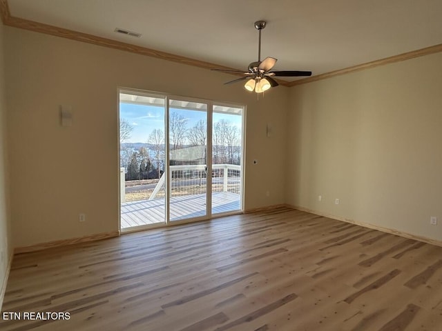 spare room with ornamental molding, baseboards, a ceiling fan, and wood finished floors