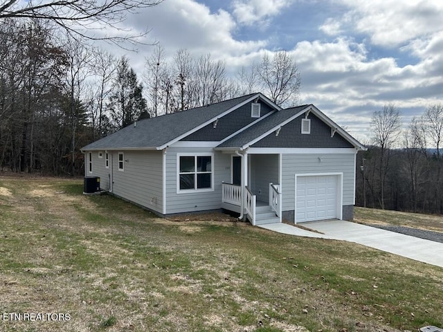 view of front of home featuring an attached garage, a front lawn, and driveway