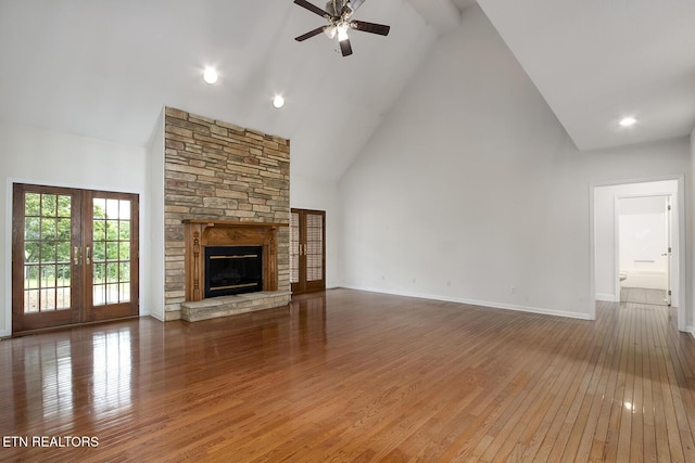 2000 Robinson Dr, Lenoir City, TN 37772 - unfurnished living room with high vaulted ceiling, a ceiling fan, wood-type flooring, a stone fireplace, and baseboards