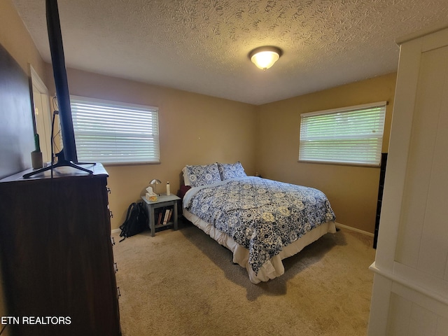 carpeted bedroom with baseboards and a textured ceiling