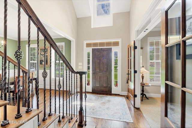 entrance foyer featuring plenty of natural light, baseboards, stairway, and a towering ceiling
