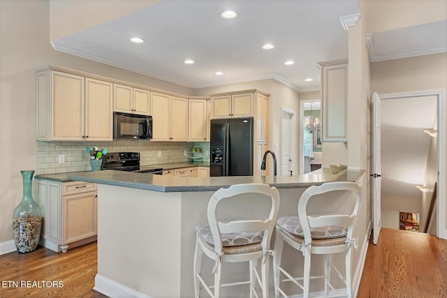kitchen with black appliances, crown molding, a peninsula, tasteful backsplash, and recessed lighting