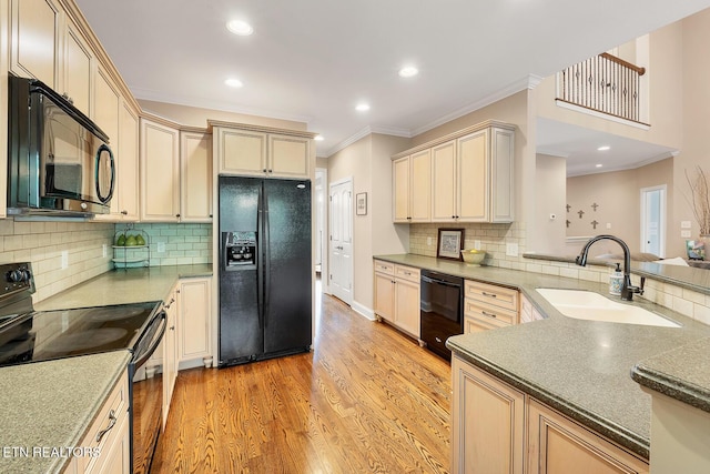 kitchen with black appliances, a sink, cream cabinets, ornamental molding, and decorative backsplash