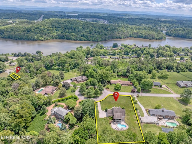 aerial view of property and surrounding area featuring a heavily wooded area, a large body of water, and property boundaries highlighted