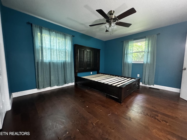 bedroom with ceiling fan, baseboards, and wood-type flooring