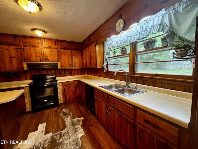 kitchen with a sink, a textured ceiling, black appliances, under cabinet range hood, and light countertops