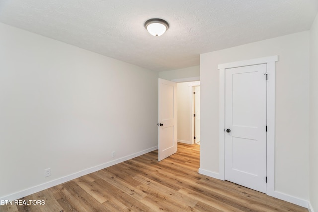 7220 Beelertown Rd, Powell, TN 37849 - unfurnished bedroom featuring light wood-style flooring, baseboards, and a textured ceiling