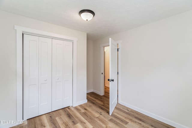 7220 Beelertown Rd, Powell, TN 37849 - unfurnished bedroom featuring light wood-style flooring, a closet, baseboards, and a textured ceiling