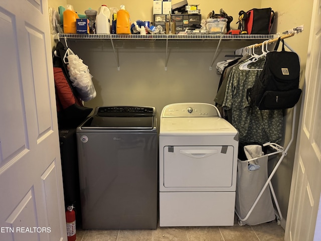 laundry room featuring independent washer and dryer, light tile patterned floors, and laundry area