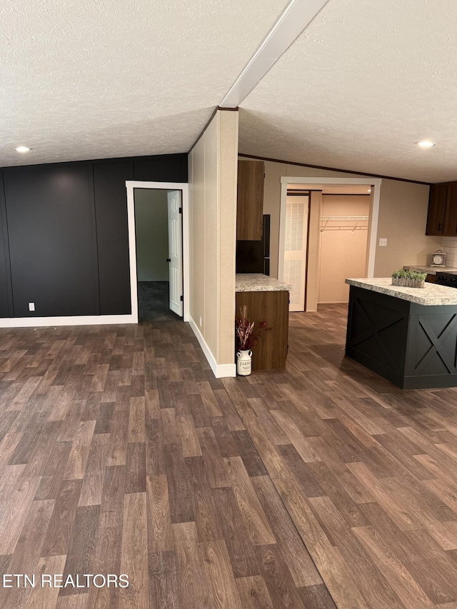 kitchen with a textured ceiling, baseboards, recessed lighting, and dark wood finished floors