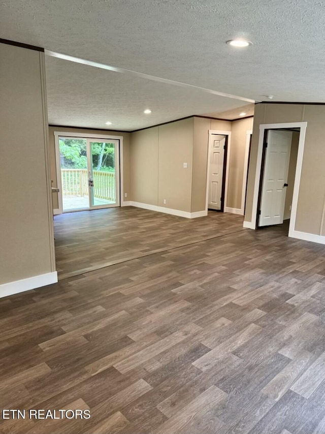 unfurnished room featuring a textured ceiling, wood finished floors, baseboards, and recessed lighting
