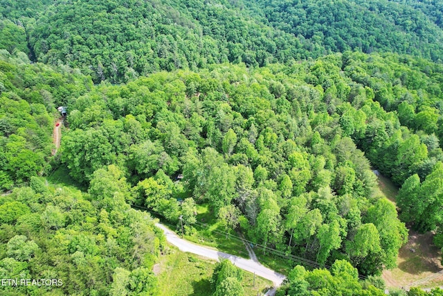 aerial view of property and surrounding area featuring a heavily wooded area
