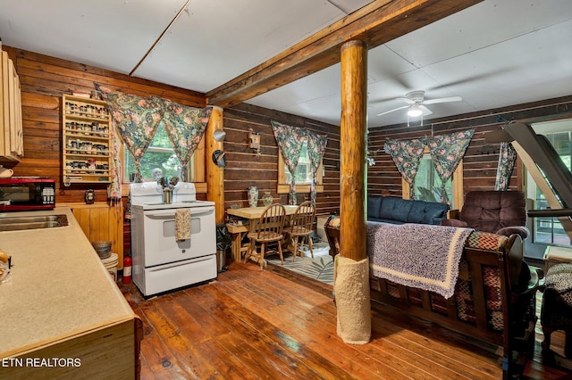 kitchen with electric range, hardwood / wood-style flooring, wood walls, black microwave, and ceiling fan