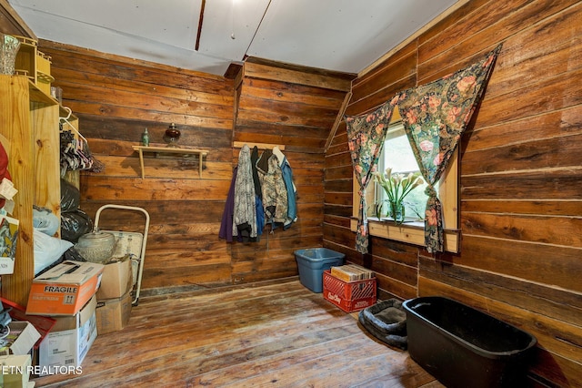 interior space featuring wooden walls, hardwood / wood-style floors, and lofted ceiling