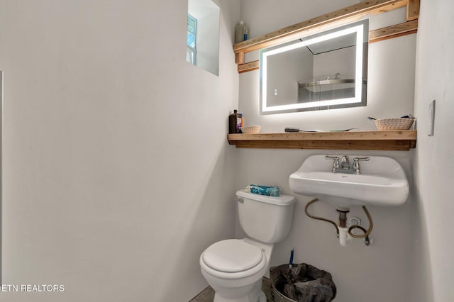 half bath featuring toilet and a sink