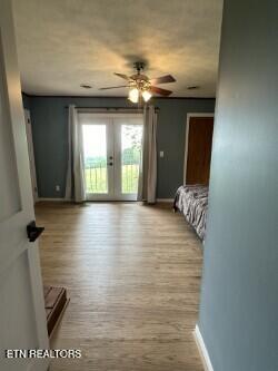 unfurnished bedroom with access to outside, french doors, baseboards, and wood finished floors