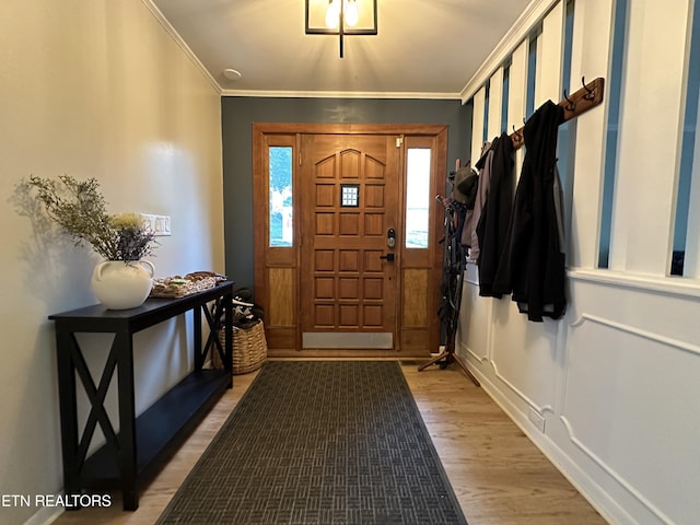 entryway with light wood-type flooring and ornamental molding