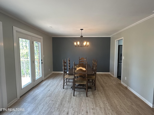dining space with baseboards, a chandelier, crown molding, and wood finished floors