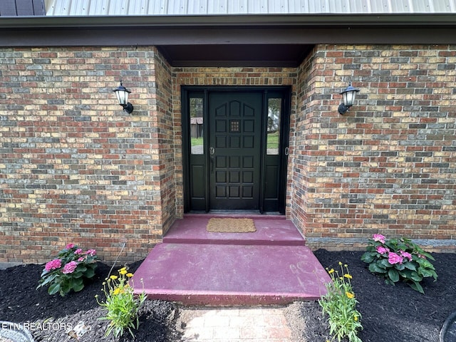 view of exterior entry with brick siding
