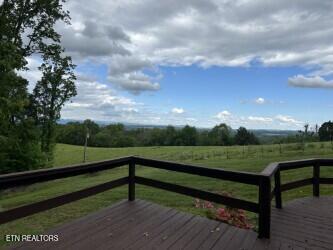 wooden deck featuring a yard and a rural view