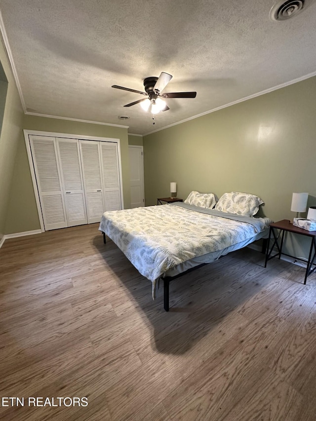 bedroom featuring crown molding, visible vents, and a closet