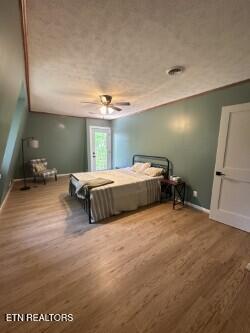 bedroom featuring a ceiling fan, wood finished floors, and baseboards