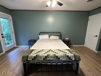 bedroom with ceiling fan, baseboards, and wood finished floors