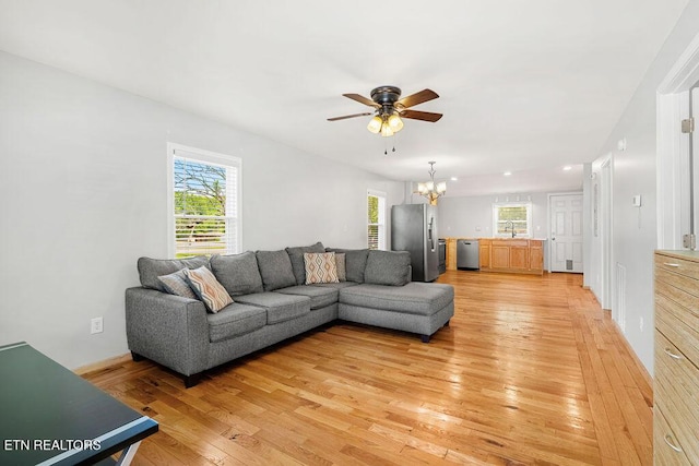 living room with light wood finished floors, ceiling fan with notable chandelier, a healthy amount of sunlight, and recessed lighting