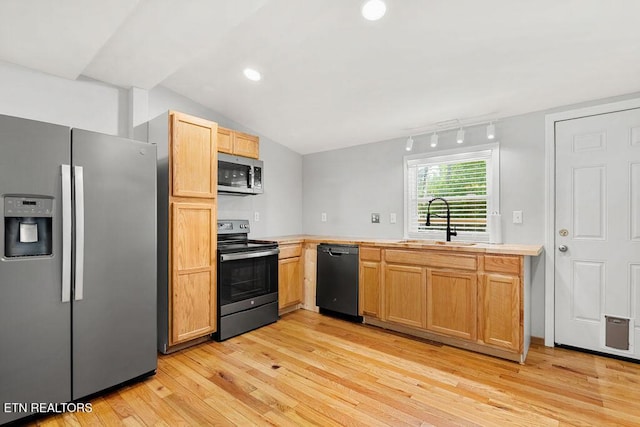 kitchen with lofted ceiling, light wood-style flooring, a sink, light countertops, and appliances with stainless steel finishes
