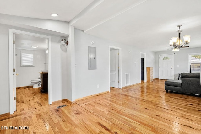living area with a notable chandelier, baseboards, visible vents, electric panel, and light wood-type flooring
