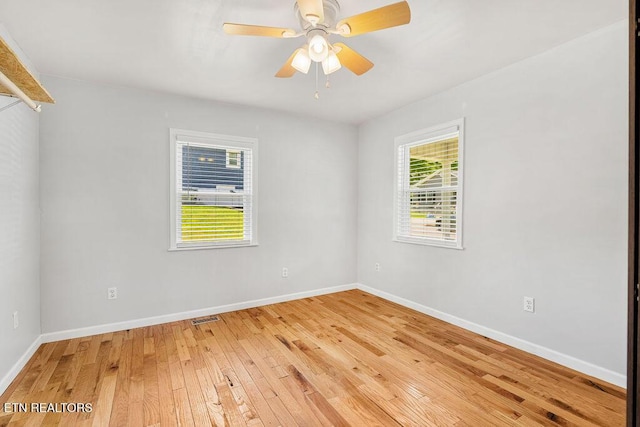spare room featuring light wood-type flooring, visible vents, baseboards, and ceiling fan