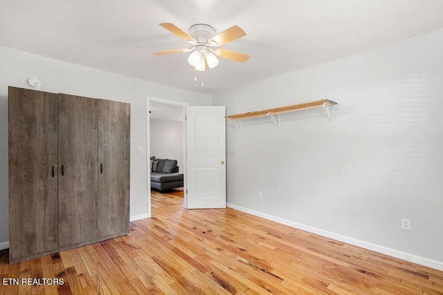 unfurnished bedroom with light wood-style floors, baseboards, and a ceiling fan