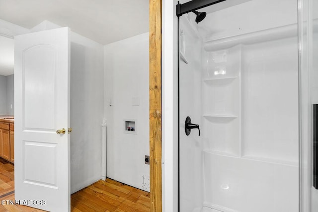 full bathroom featuring walk in shower, vanity, and wood finished floors