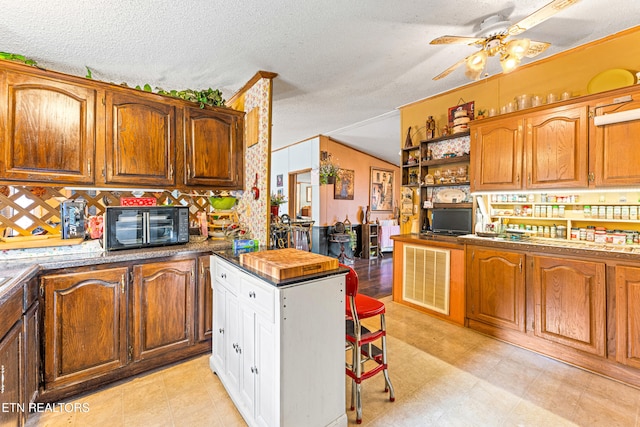 7726 Misty Point Way, Knoxville, TN 37914 - kitchen with ceiling fan, a textured ceiling, light floors, and brown cabinets
