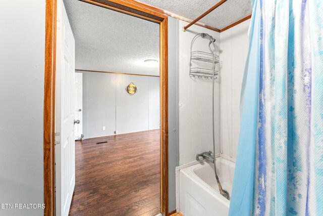 7726 Misty Point Way, Knoxville, TN 37914 - bathroom with a textured ceiling, wood finished floors, shower / bathtub combination with curtain, and ornamental molding